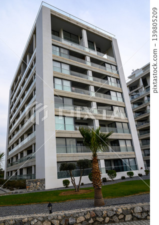 Modern architectural marvel stands tall against a cloudy sky in a vibrant urban setting Modern architectural marvel stands tall against a cloudy sky in a vibrant urban setting 139805209