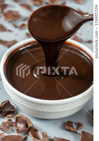 Smooth melting chocolate sauce flowing from a spoon Smooth melting chocolate sauce flowing from a spoon 139805504