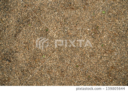 Flat lay of granular sandy soil ground surface, ideal for natural wallpaper, textured screensavers 139805644
