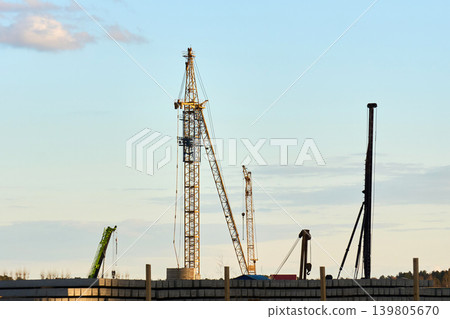 Tower crane at a residential construction site at sunset Tower crane at a residential construction site at sunset 139805670
