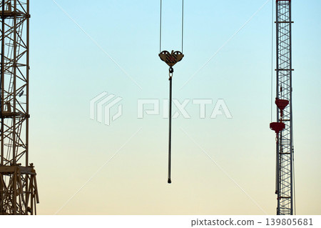 Crane hooks and steel cables against clear blue sky 139805681