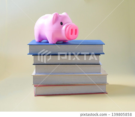 Piggy bank on a stack of hard cover books. 139805858