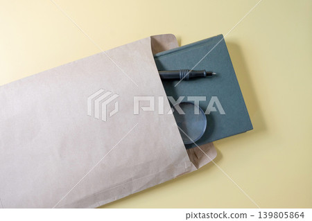 Hard cover book in document envelope on background. Hard cover book in document envelope on background. 139805864
