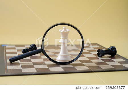 Chess pieces is viewed through a magnifying glass. Chess pieces is viewed through a magnifying glass. 139805877