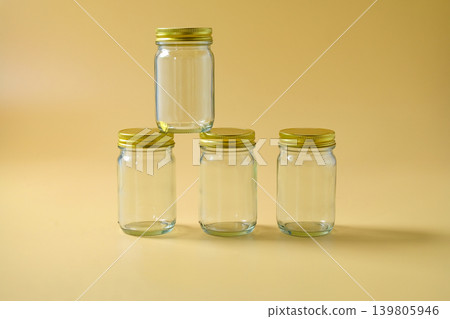 A glass storage jar with a gold metallic lid. A glass storage jar with a gold metallic lid. 139805946