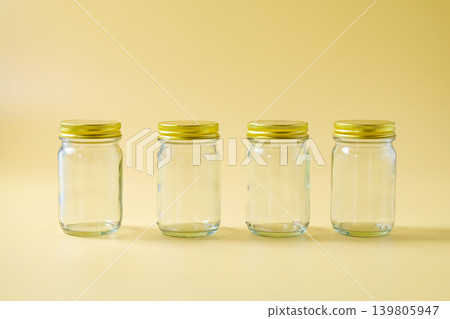 A glass storage jar with a gold metallic lid. A glass storage jar with a gold metallic lid. 139805947
