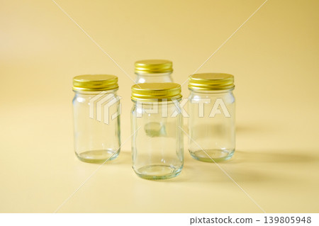 A glass storage jar with a gold metallic lid. A glass storage jar with a gold metallic lid. 139805948