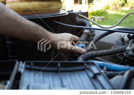 Mechanic hand checking engine fluid level in a jeep Mechanic hand checking engine fluid level in a jeep 139806150