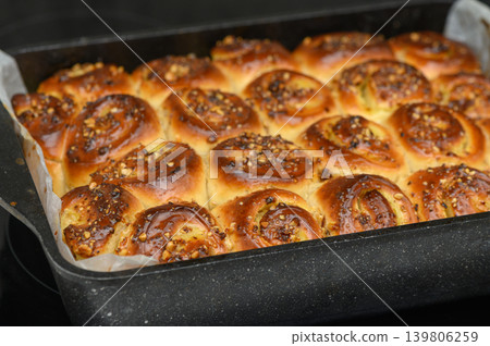 Homemade sweet rolls with a golden crust and crunchy topping fresh from the oven in a cozy kitchen setting 139806259