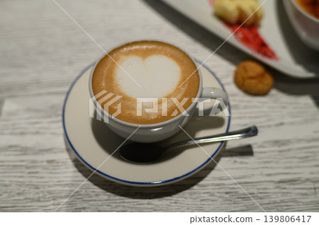 Delightful coffee art with a heart shape crafted atop a creamy surface in a cozy cafe setting Delightful coffee art with a heart shape crafted atop a creamy surface in a cozy cafe setting 139806417