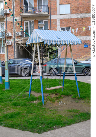 Children swing with striped canopy on playground Children swing with striped canopy on playground 139806577