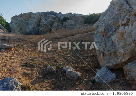 Exploring rugged terrain on a sunny day at the rocky hillside. Exploring rugged terrain on a sunny day at the rocky hillside. 139806580
