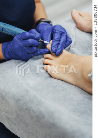Professional technician cares for client's foot nails Professional technician cares for client's foot nails 139806734