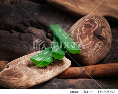 Fresh cut aloe vera leaves on natural wood. Organic skin care ingredient, herbal medicine, and beauty product component concept. Fresh cut aloe vera leaves on natural wood. Organic skin care ingredient, herbal medicine, and beauty product component concept. 139806898