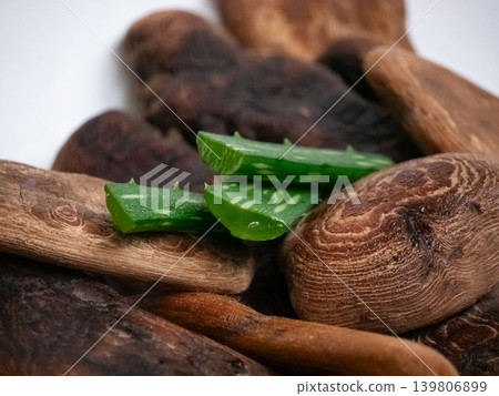 Fresh cut aloe vera slices on natural driftwood pieces for skincare and beauty product display. Holistic wellness and organic cosmetic ingredient. Fresh cut aloe vera slices on natural driftwood pieces for skincare and beauty product display. Holistic wellness and organic cosmetic ingredient. 139806899