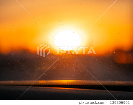 Bright sun with bokeh effect shining through a dusty car windshield. Golden hour light for sunrise or sunset imagery. Bright sun with bokeh effect shining through a dusty car windshield. Golden hour light for sunrise or sunset imagery. 139806901