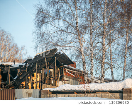 Charred remains of a destroyed house after fire incident in winter. Concept of disaster, loss, safety, insurance. Charred remains of a destroyed house after fire incident in winter. Concept of disaster, loss, safety, insurance. 139806980