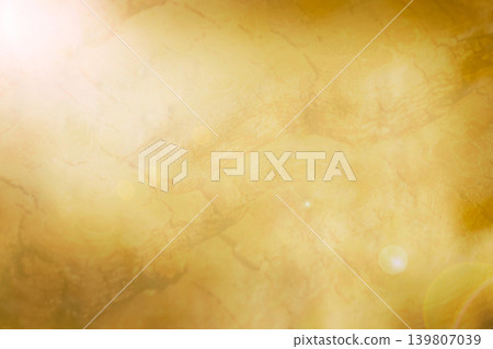 Gold texture background with a subtle gradient shadow and bright lens flare. Abstract design for luxury concept. 139807039