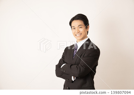 一個雙臂交叉、面帶微笑的男人。 一個雙臂交叉、面帶微笑的男人。 139807094