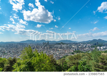 Beautiful spring afternoon cityscape of Seoul seen from Yongmasan Mountain with green trees and puffy clouds, South Korea Beautiful spring afternoon cityscape of Seoul seen from Yongmasan Mountain with green trees and puffy clouds, South Korea 139807565