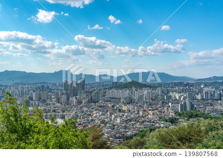 Beautiful spring afternoon cityscape of Seoul seen from Yongmasan Mountain with green trees and puffy clouds, South Korea Beautiful spring afternoon cityscape of Seoul seen from Yongmasan Mountain with green trees and puffy clouds, South Korea 139807568