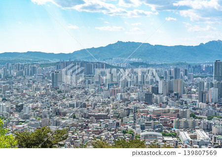 Beautiful spring afternoon cityscape of Seoul seen from Yongmasan Mountain with green trees and puffy clouds, South Korea Beautiful spring afternoon cityscape of Seoul seen from Yongmasan Mountain with green trees and puffy clouds, South Korea 139807569