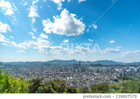 Beautiful spring afternoon cityscape of Seoul seen from Yongmasan Mountain with green trees and puffy clouds, South Korea Beautiful spring afternoon cityscape of Seoul seen from Yongmasan Mountain with green trees and puffy clouds, South Korea 139807570