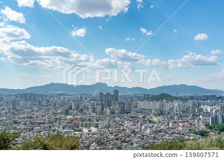 Beautiful spring afternoon cityscape of Seoul seen from Yongmasan Mountain with green trees and puffy clouds, South Korea Beautiful spring afternoon cityscape of Seoul seen from Yongmasan Mountain with green trees and puffy clouds, South Korea 139807571