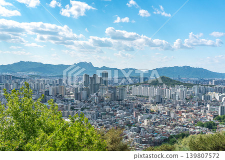 Beautiful spring afternoon cityscape of Seoul seen from Yongmasan Mountain with green trees and puffy clouds, South Korea Beautiful spring afternoon cityscape of Seoul seen from Yongmasan Mountain with green trees and puffy clouds, South Korea 139807572