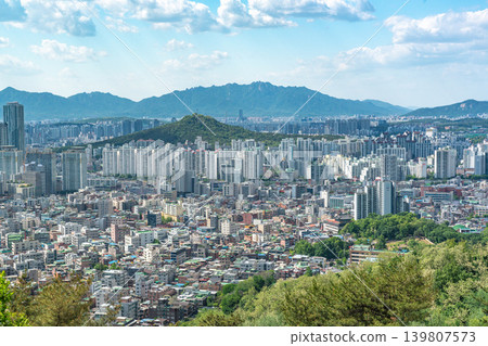 Beautiful spring afternoon cityscape of Seoul seen from Yongmasan Mountain with green trees and puffy clouds, South Korea Beautiful spring afternoon cityscape of Seoul seen from Yongmasan Mountain with green trees and puffy clouds, South Korea 139807573