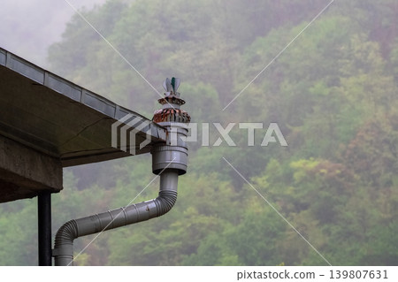 Rainwater drains from a metal gutter 139807631