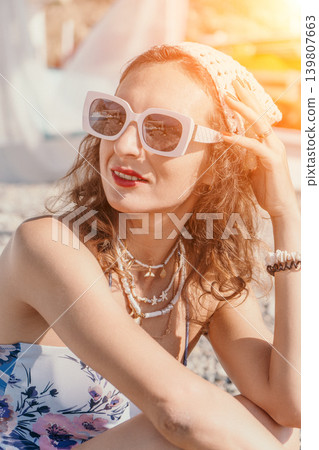 Woman beach sunglasses relaxing on a pebble shore wearing bohemian jewelry during a sunny summer vacation 139807663