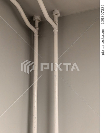 Vertical White Utility Pipes Entering Room Ceiling Corner Vertical White Utility Pipes Entering Room Ceiling Corner 139807825