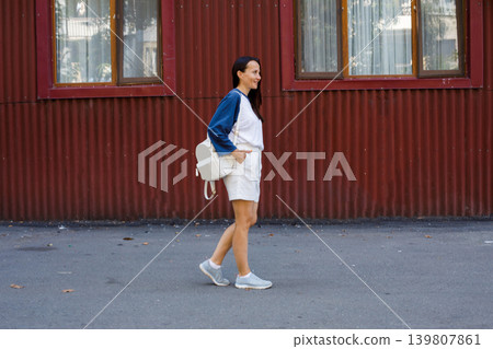 Beautiful woman with long dark hair smiling and walking in old town Beautiful woman with long dark hair smiling and walking in old town 139807861