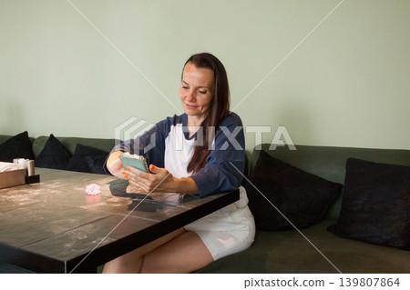 Healthy woman using smartphone. Beautiful woman with long dark hair holding mobile phone Healthy woman using smartphone. Beautiful woman with long dark hair holding mobile phone 139807864