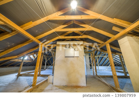Attic of a building with wooden beams of a roof structure. Attic of a building with wooden beams of a roof structure. 139807959