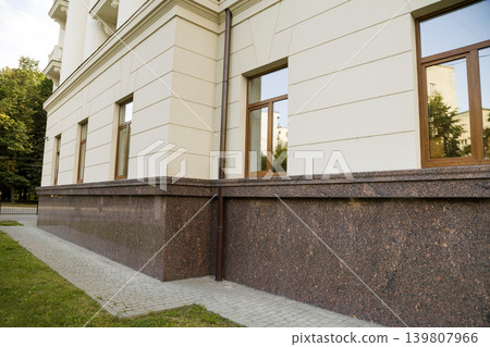 Close up view of part of a building facade with the surface of granite wall. Natural stone materials. Close up view of part of a building facade with the surface of granite wall. Natural stone materials. 139807966
