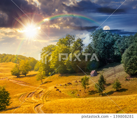 view of mountain meadow. day meet night. sun and moon over countryside equinox landscape with beech forest on the grassy field on hill. epic sky. alpine background for travel through highland view of mountain meadow. day meet night. sun and moon over countryside equinox landscape with beech forest on the grassy field on hill. epic sky. alpine background for travel through highland 139808281