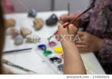 Children Painting Stones With Colorful Paints During Creative Craft Activity. Children Painting Stones With Colorful Paints During Creative Craft Activity. 139808926