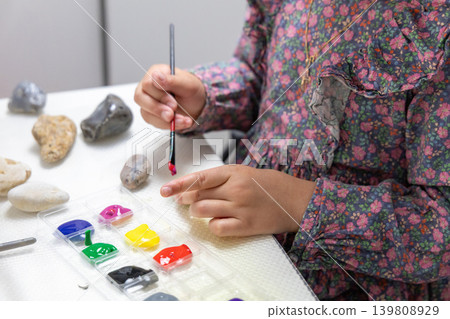 Creative Children Crafting and Painting Pebbles at Home or School. 139808929
