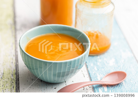 Creamy Pumpkin Baby Food Puree In Blue Bowl With Glass Jars And Pink Spoon On Rustic Table Creamy Pumpkin Baby Food Puree In Blue Bowl With Glass Jars And Pink Spoon On Rustic Table 139808996
