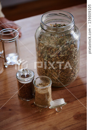 Jar, tea leaves and herbal plant on kitchen counter or health benefits or morning beverage, refreshing or wellness. Bottle, vitality and prepare as hot drinking or jasmine, hibiscus or stress relief Jar, tea leaves and herbal plant on kitchen counter or health benefits or morning beverage, refreshing or wellness. Bottle, vitality and prepare as hot drinking or jasmine, hibiscus or stress relief 139809105