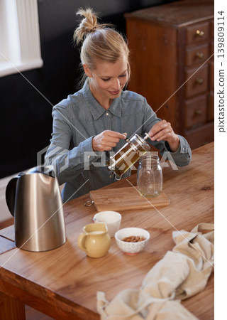 Woman, happy and tea of herbs in home and warm beverage of herbal mixture for health wellness. House, homeopath and detox with dry leaves in plunger and chamomile drink to relax in kitchen by table Woman, happy and tea of herbs in home and warm beverage of herbal mixture for health wellness. House, homeopath and detox with dry leaves in plunger and chamomile drink to relax in kitchen by table 139809114