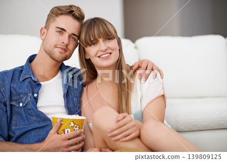Couple, watch and tv for movies, popcorn and smile on face, happiness and relax with film. Streaming, hug and sitting on floor, living room or lounge and together for love, relationship and date Couple, watch and tv for movies, popcorn and smile on face, happiness and relax with film. Streaming, hug and sitting on floor, living room or lounge and together for love, relationship and date 139809125