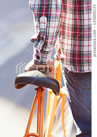 Hands, person and travel on bicycle in city on eco friendly transport outdoor, commute or walk. Cycling, back or push bike in urban town, street or road for journey with rear view of seat on sidewalk Hands, person and travel on bicycle in city on eco friendly transport outdoor, commute or walk. Cycling, back or push bike in urban town, street or road for journey with rear view of seat on sidewalk 139809133