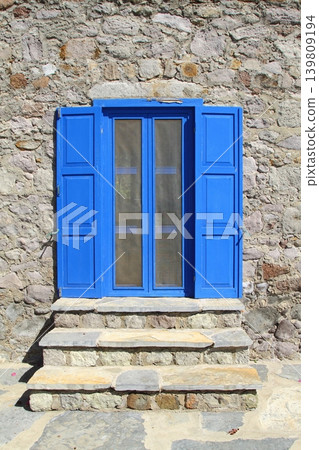 house with blue windows on stone house. house with blue windows on stone house. 139809194