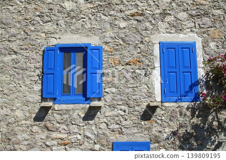 house with blue windows on stone house. 139809195