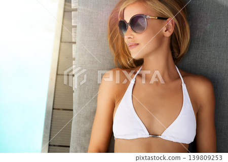 Woman, bikini and swimming pool or sunbathing in summer with sunglasses on patio furniture or holiday, vacation or rest. Female person, eyewear and water in Miami or travel, sunshine or stress relief Woman, bikini and swimming pool or sunbathing in summer with sunglasses on patio furniture or holiday, vacation or rest. Female person, eyewear and water in Miami or travel, sunshine or stress relief 139809253