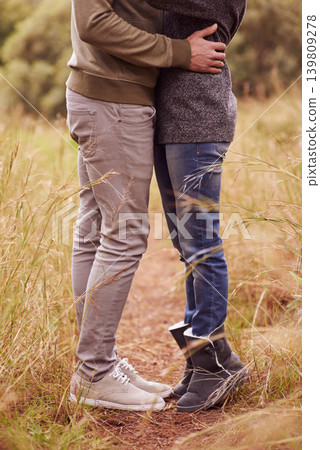 Love, legs and hug with couple in countryside together for romance, bonding or dating on field of grass. Nature, earth or environment with man and woman embracing outdoor for anniversary closeup Love, legs and hug with couple in countryside together for romance, bonding or dating on field of grass. Nature, earth or environment with man and woman embracing outdoor for anniversary closeup 139809278