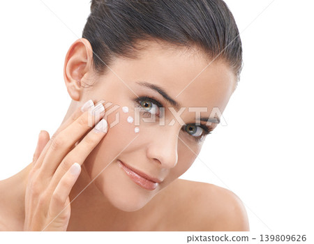 Happy woman, portrait and skincare with face cream, lotion or cosmetics on a white studio background. Face of female person, brunette or model applying creme or moisturizer for healthy skin or glow Happy woman, portrait and skincare with face cream, lotion or cosmetics on a white studio background. Face of female person, brunette or model applying creme or moisturizer for healthy skin or glow 139809626